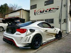 a white sports car parked in front of a building