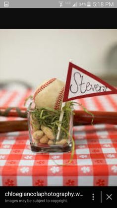 a small glass vase filled with food on top of a red and white checkered table cloth