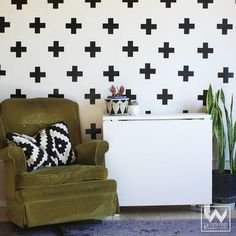 a green chair sitting in front of a wall with black crosses on it's walls