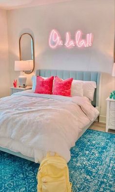 a bedroom with blue carpet, white bedding and neon lights on the wall above it