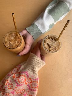 two people are holding drinks in their hands, one is filled with liquid and the other has ice cream