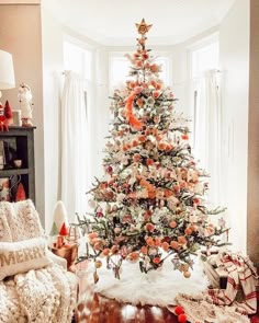 an instagram christmas tree is decorated with orange and white ornaments, while the bottom one has