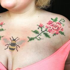 a woman wearing a pink dress with flowers on her chest and a bee in the middle