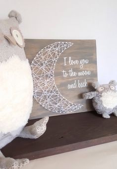 two stuffed animals are sitting next to a sign that says i love you to the moon and back