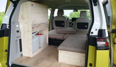 the interior of a yellow van with its doors open and seats folded back to allow extra storage space