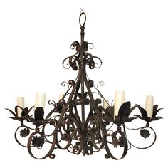 an iron chandelier with five candles on it