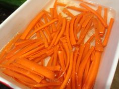 sliced carrots are in a white container on the counter