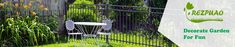 a fenced in garden with a chair and table on the grass next to it