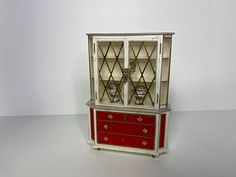 a red and white china cabinet sitting on top of a table