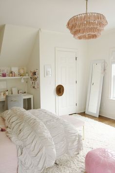 a bedroom with white bedding and pink accessories