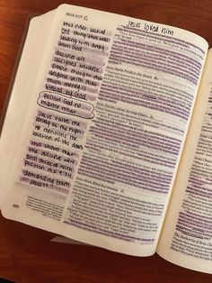 an open bible on a wooden table with the words in different languages written below it