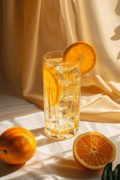 two oranges and one grapefruit are on the table with some water in it