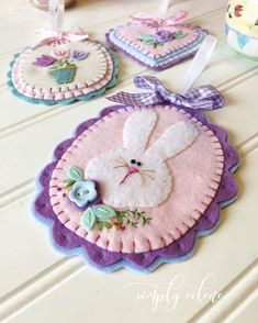 three felt easter bunnies are sitting on a table