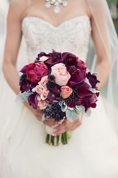 the bride is holding her wedding bouquet in her hand and looking at the camera screen