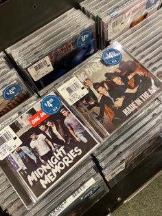 cd's are stacked on top of each other in a store display case for sale