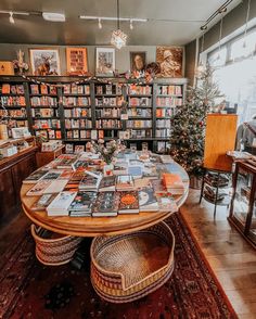 a table with many books on it in front of a bookcase full of books