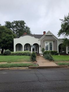 a white house sitting on the side of a road