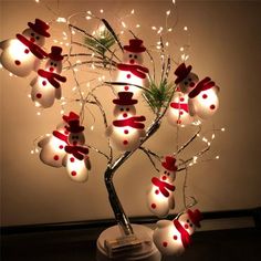 a christmas tree with snowmen and lights in the shape of hearts on it's branches