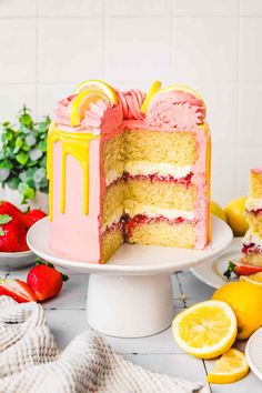 a cake that is on a plate with lemons and strawberries in the background