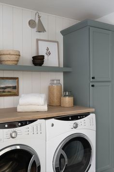 a washer and dryer in a laundry room with shelves above them, along with other items