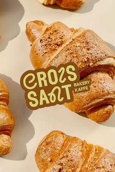 some croissants are sitting on a table with a sticker that says cross saqt