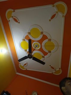 a clock that is on the side of a wall in a room with orange walls