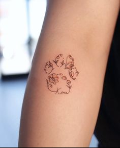 a person with a tattoo on their arm that has cats and dogs in the center