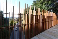 a long wooden fence next to a body of water