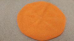 an orange knitted hat laying on the floor