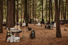 a group of people standing around tables in the woods