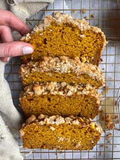 a person touching the inside of a loaf of pumpkin bread