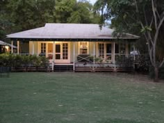 a small white house sitting on top of a lush green field