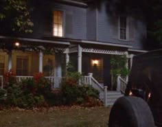 a truck parked in front of a house at night with lights on the porch and door