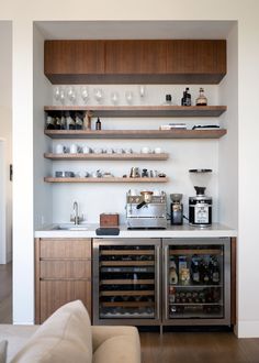 a kitchen with open shelves filled with bottles and glasses