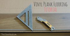 a pair of tools sitting on top of a wooden table next to a sign that says vinyl plank flooring