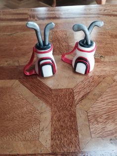 two ceramic golf clubs sitting on top of a wooden table