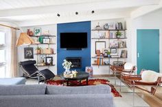 a living room filled with furniture and a flat screen tv mounted on the wall above a fireplace