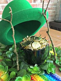 a green hat sitting on top of a wooden table next to some plants and coins