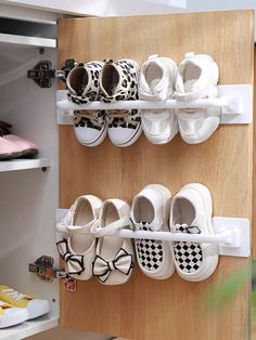 several pairs of shoes are hanging on the wall