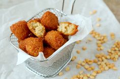 a basket filled with fried food on top of a table next to corn flakes