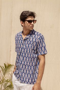 Stay cool and stylish in the Bluebell unisex summer shirt. Featuring a symmetrical tree motif on a blue backdrop, this handblock printed shirt is perfect for adding a touch of fun and comfort to your wardrobe. (Tree-mendous style and breezy vibes guaranteed!) Cabana collar, Relaxed fit 100% Cotton Handmade in India *Please note colors can vary slightly from screen to in person. Small variations add to the beauty of the product. Patterned Cotton Camp Collar Tops, Patterned Cotton Top With Camp Collar, Relaxed Fit Cotton Camp Shirt In Patterned Color, Relaxed Fit Patterned Cotton Camp Shirt, Printed Blue Shirt For Summer, Blue Printed Shirt For Summer, Printed Cotton Shirt With Camp Collar, Indigo Cotton Short Sleeve Shirt, Blue Printed Shirt With Camp Collar