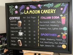 a menu board with drinks on it in front of a sign that says la lagoon bakery