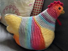 a crocheted chicken sitting on top of a couch