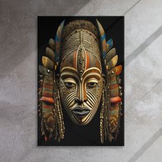 a painting of a mask with feathers on it's head is hanging on the wall