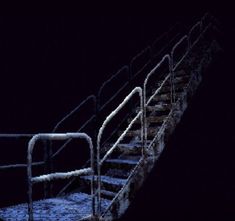 the stairs are covered in snow at night, with no people on them or one person walking up it