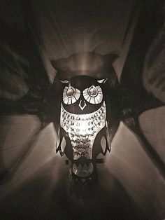 an owl lamp is lit up in the dark