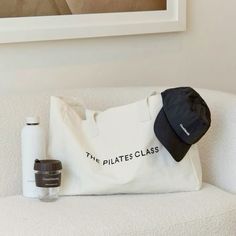 a white bag sitting on top of a couch next to a bottle