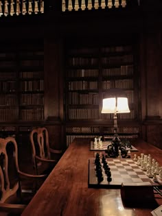 a long table with chess on it in front of a bookcase filled with books