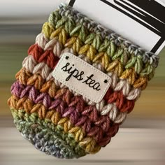 a crocheted bag with a name tag hanging from it