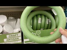 a person is holding a green wreath in front of some toilet paper and other items